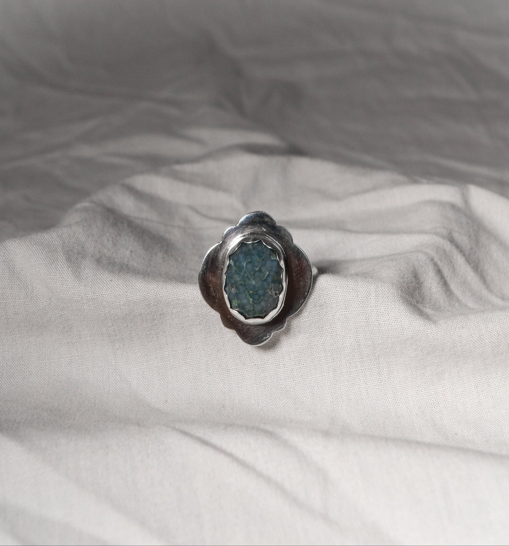 Ring with a blue stone on a white fabric background